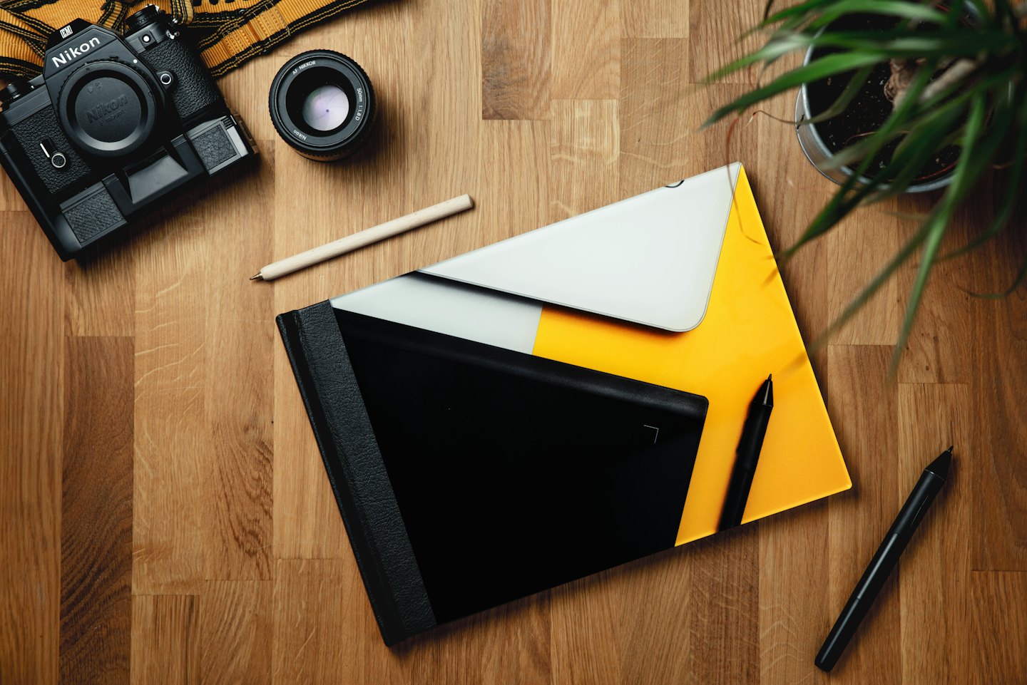 Professional design tools arranged on a wooden desk.